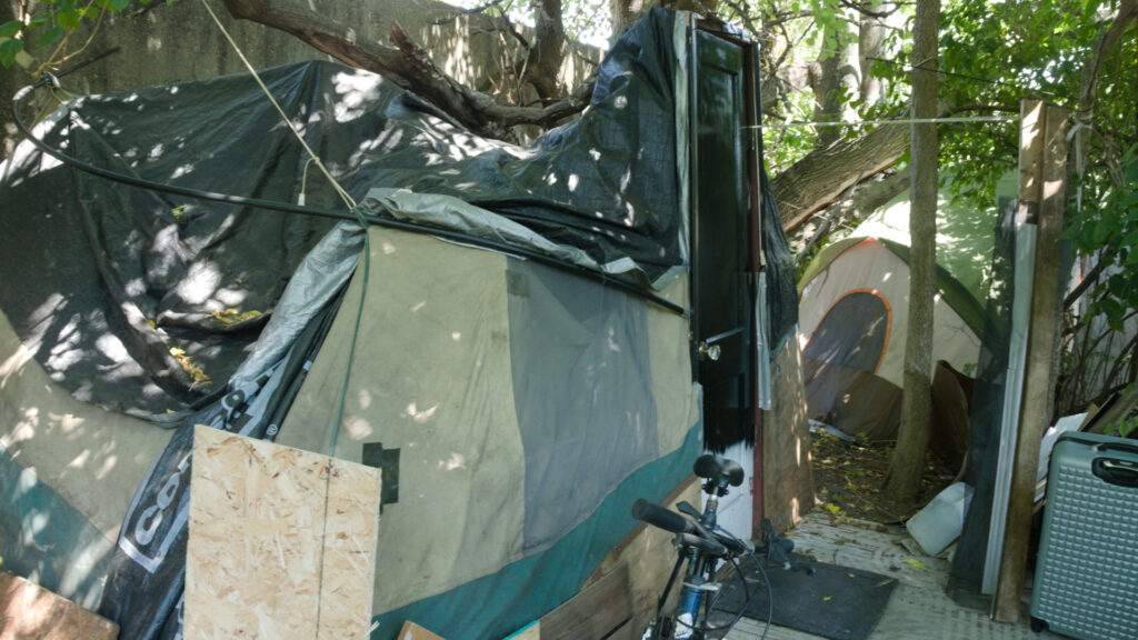 Tent of homeless person with a door at the tent entrance & bycicle